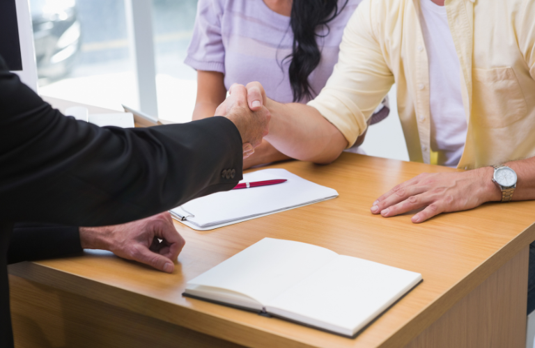 Customers with a sales person at a dealership