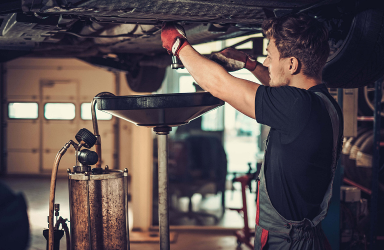 Mechanic changing oil of a vehicle 